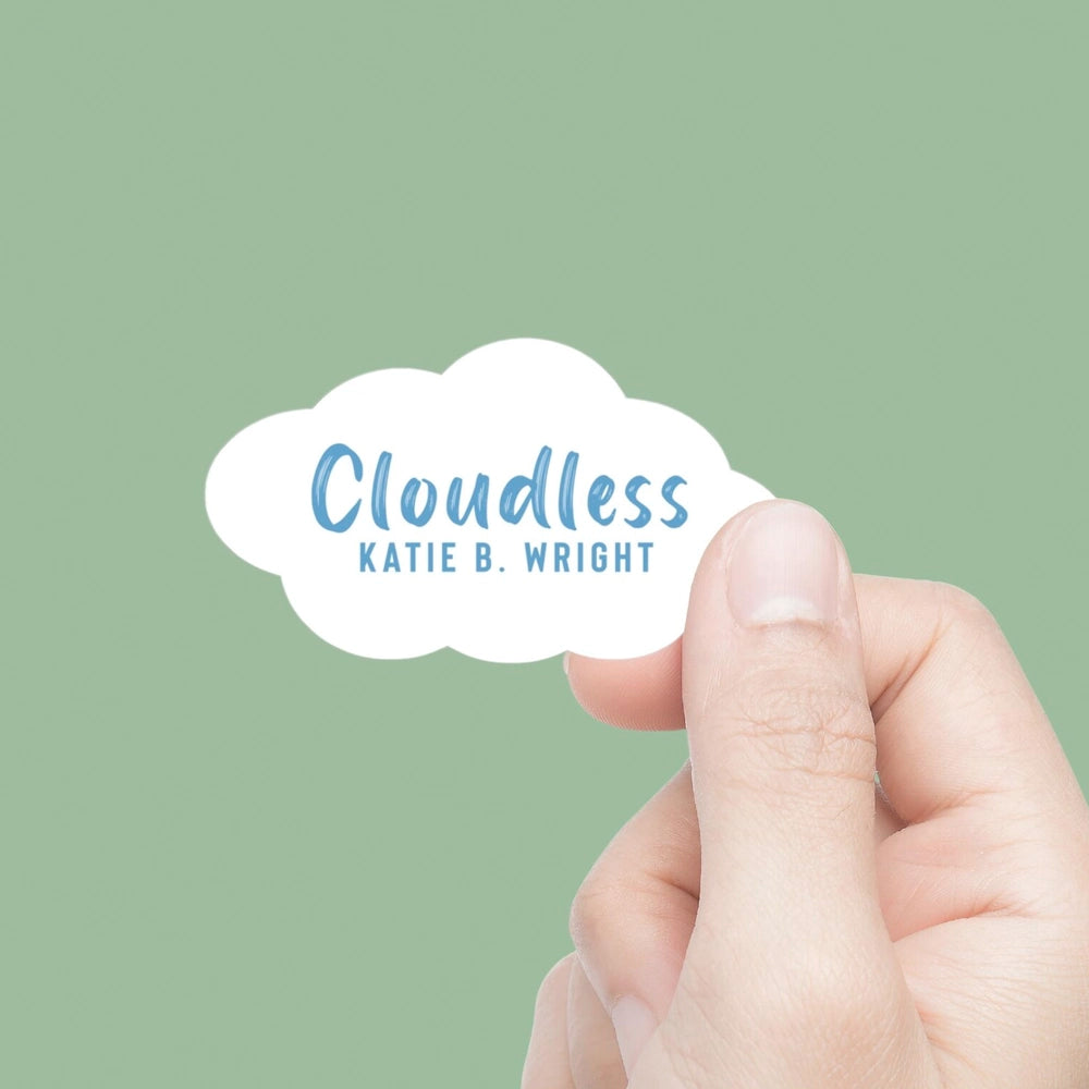 Hand holding a cloud-shaped card with 'Cloudless' and 'Katie B. Wright' text on a green background
