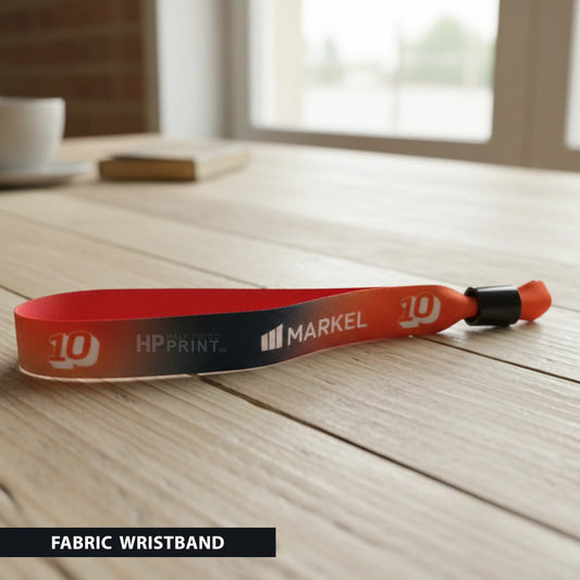 Fabric wristband with Markel and HP Print logos on a wooden surface