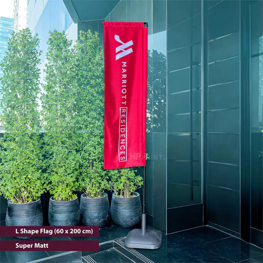 Marriott Residences flag hanging outside a building with plants and a modern facade.