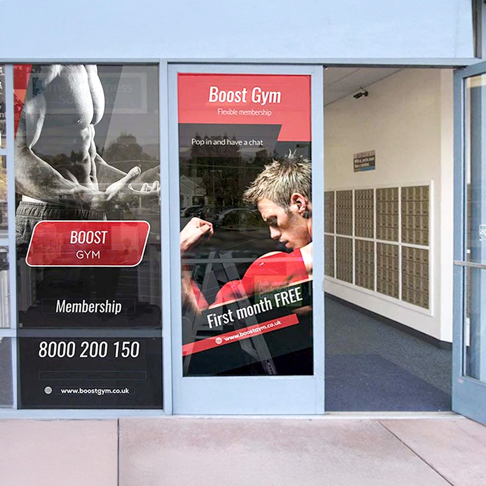 Boost Gym advertisement on glass doors with promotional text and contact information.