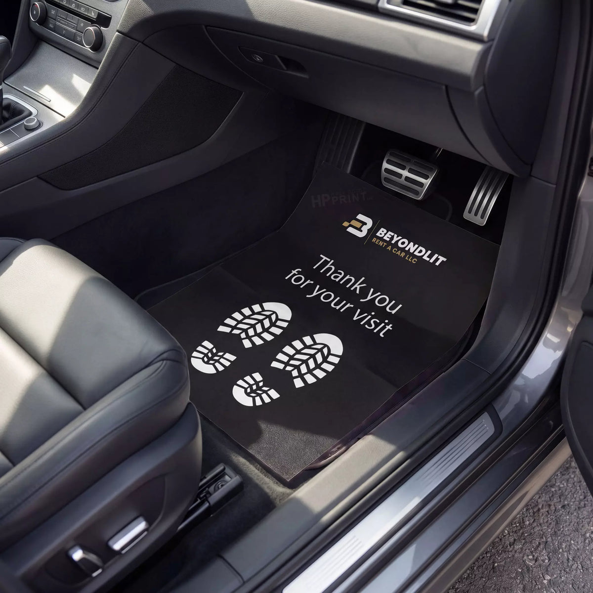 Car interior with black floor mats featuring 'Beyondlit' branding and text.