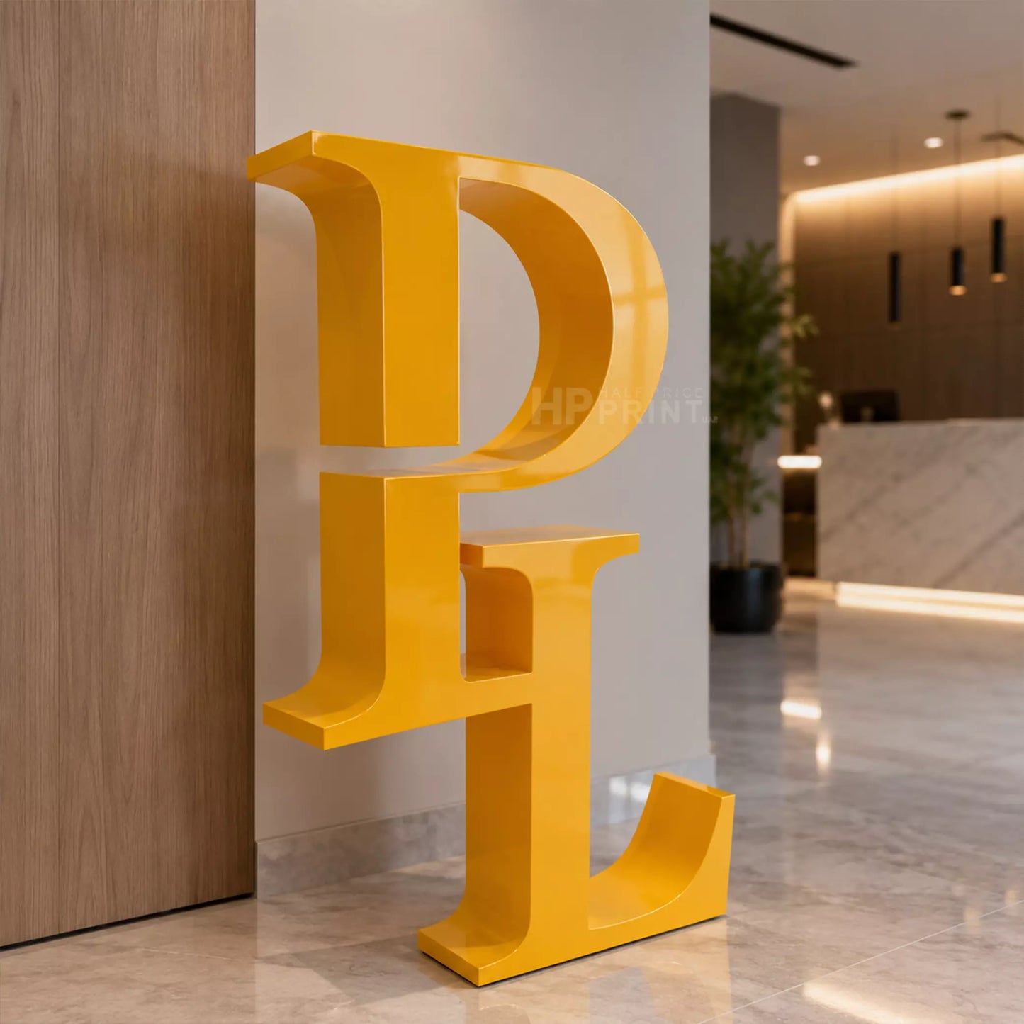 A large, bold yellow 3D letter decorative letter 'L' sculpture or wall art piece, shown in a modern office lobby setting.