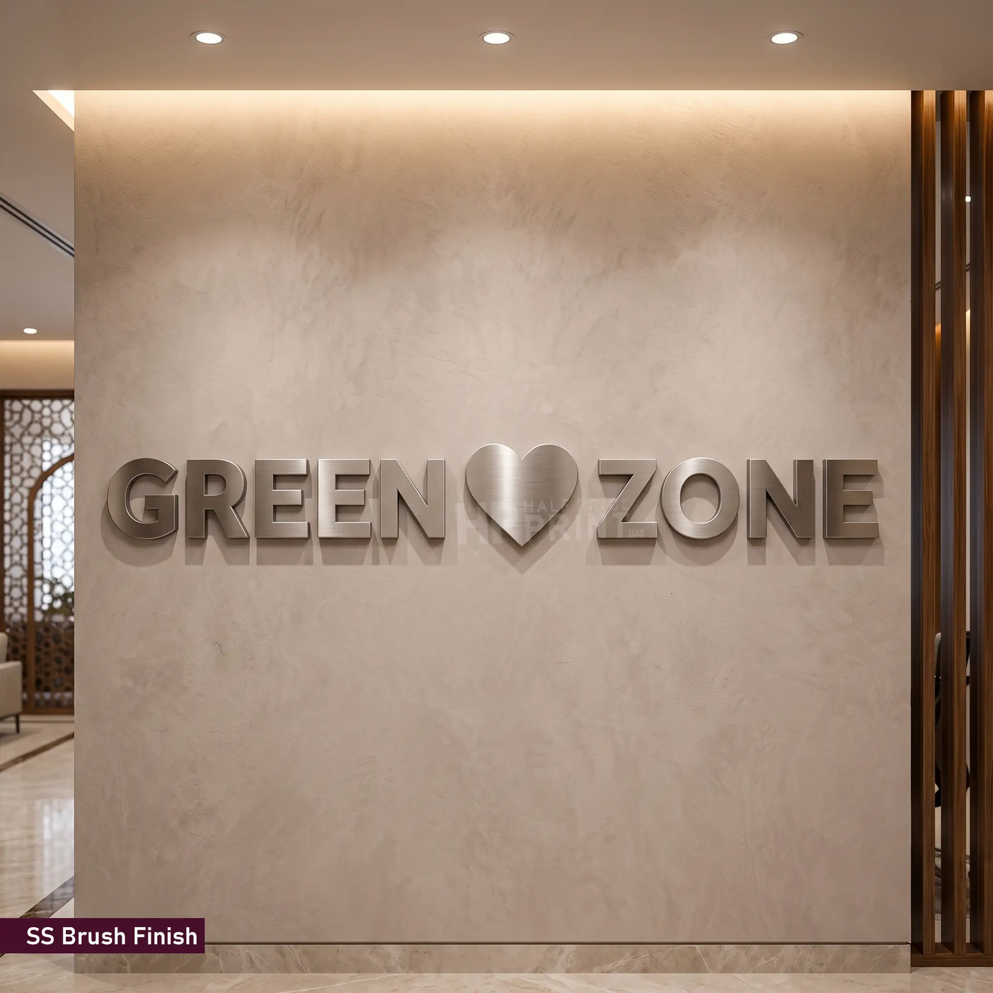 3D metal wall art featuring the text 'GREEN' and 'ZONE' with a heart symbol in the center, mounted on a textured beige wall. The letters have a brushed silver finish, and a small label in the bottom-left corner reads 'SS Brush Finish'.