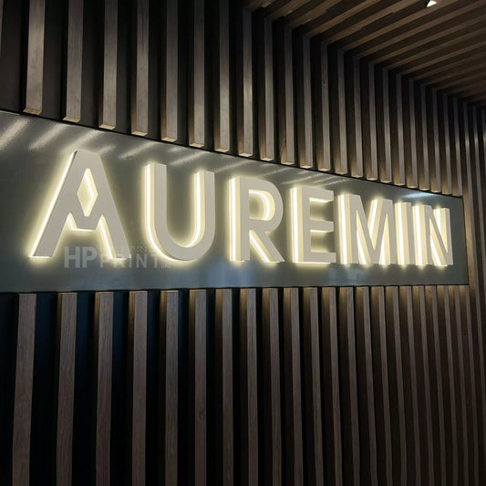 Neon sign with 'AUREMIN' on a textured wall