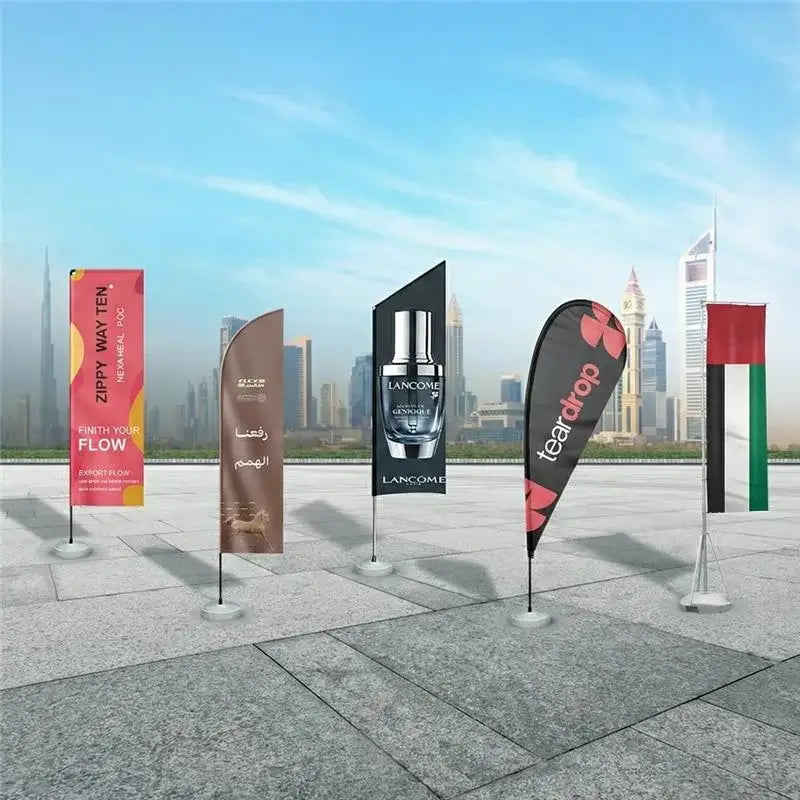 Collection of promotional flags with various designs and branding in an outdoor setting.