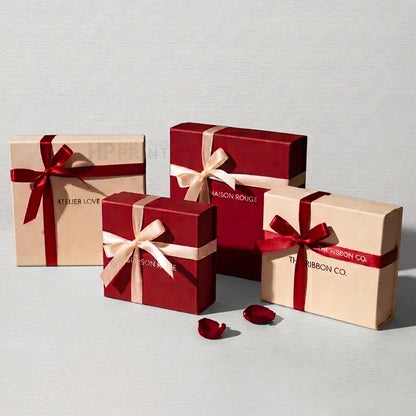 Five gift boxes in two colors: deep red and beige. Three red boxes are wrapped in beige satin ribbon with red bows, and two beige boxes are wrapped in red satin ribbon with beige bows.