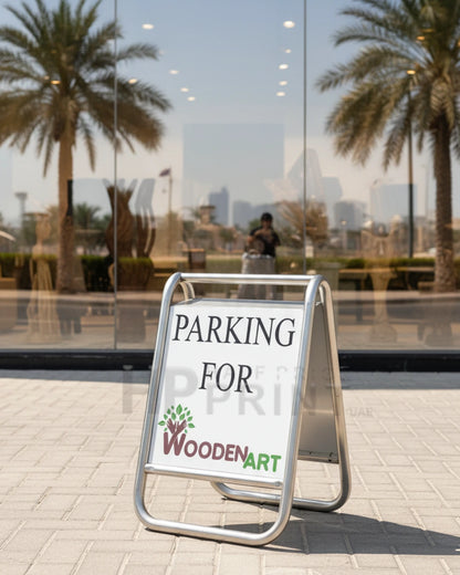 Parking sign for WoodenArt in front of a reflective glass building with palm trees.