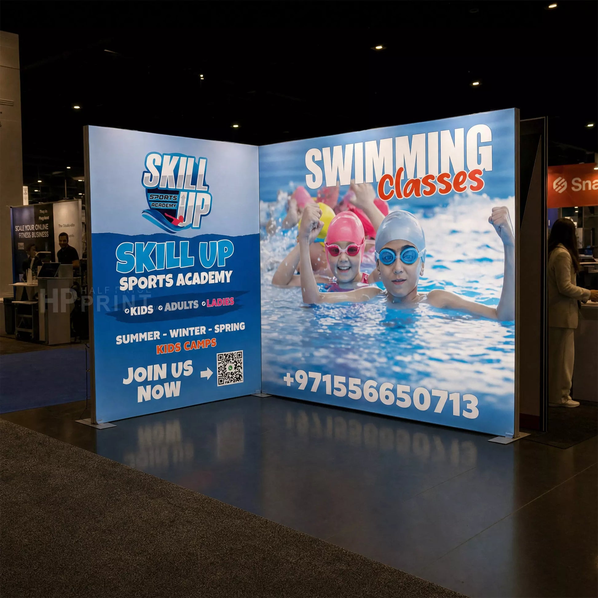 Backlit trade show display stand for Skill Up Sports Academy with children swimming in a pool.