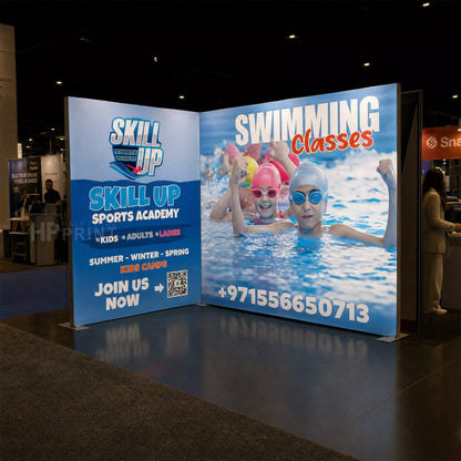 Backlit trade show display stand for Skill Up Sports Academy with children swimming in a pool.