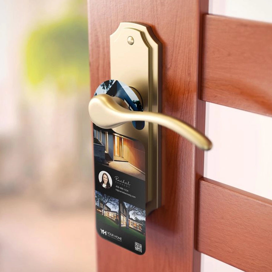 Alt text: A brass door handle on a wooden door with a real estate door hanger displaying a home photo, agent headshot, and contact information.