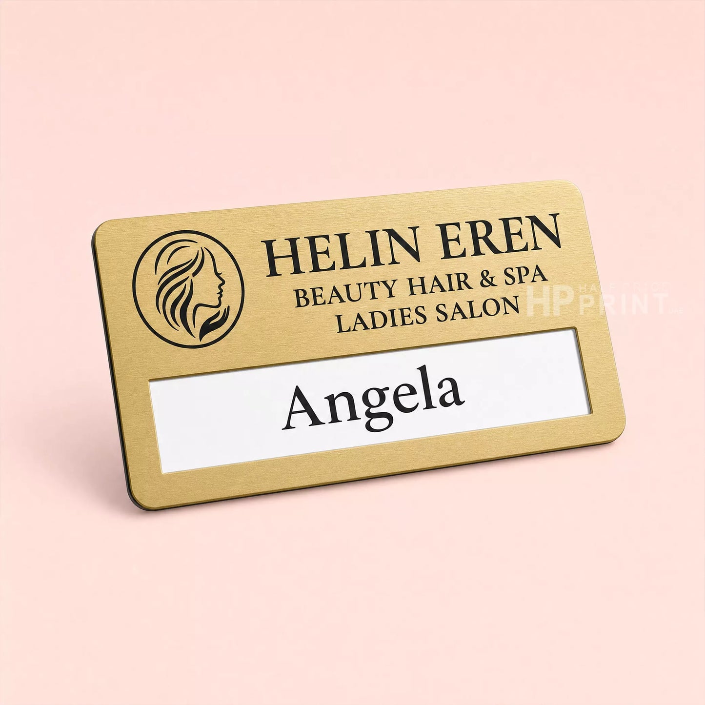 Gold name tag with 'Helin Eren Beauty Hair & Spa Ladies Salon' on a pink background