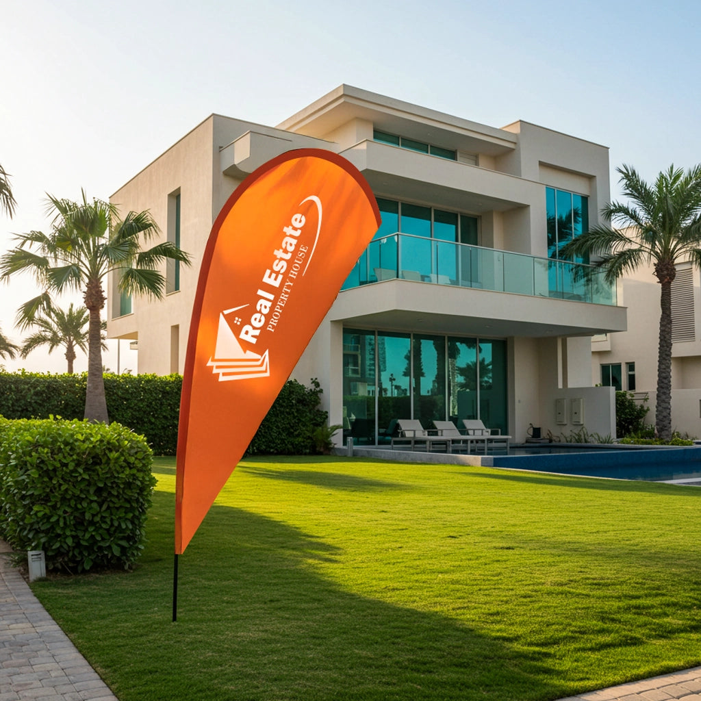 Orange real estate flag in front of a modern building with palm trees