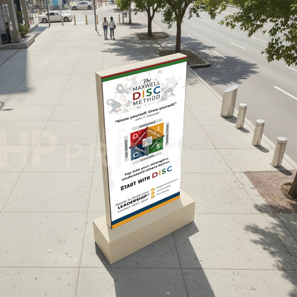 Digital totem display stand on a sidewalk with an advertisement for 'The Maxwell DISC Method' on a city street.