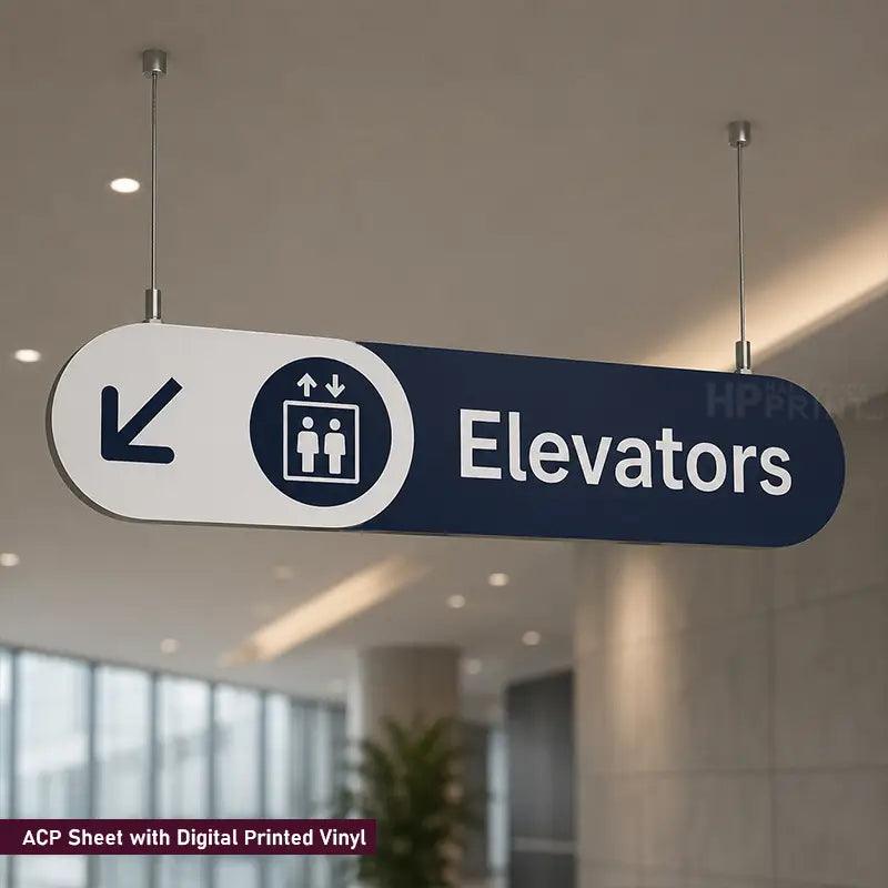 A directional hanging sign for elevators in a modern indoor space. The sign is white and dark blue, featuring a left-pointing arrow, an elevator icon, and the word 'Elevators' in white text.