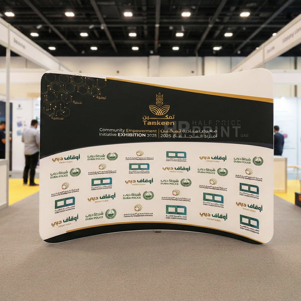 Exhibition stand with multiple logos at an event, featuring the Tamkeen logo.