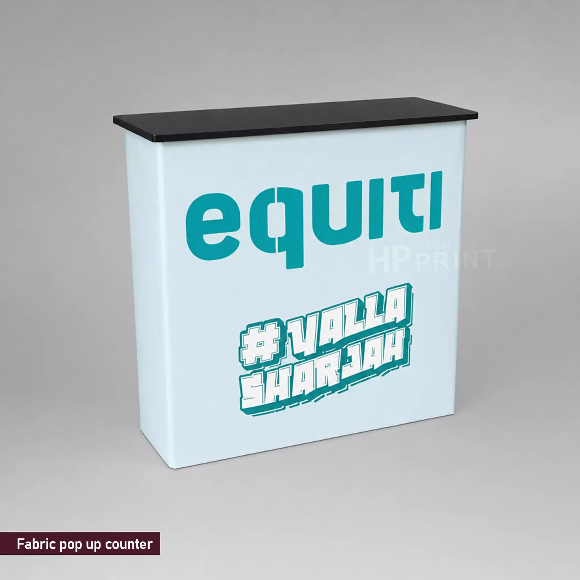 Fabric pop-up counter with 'equiti' and '#VallaShorjah' text on a gray background