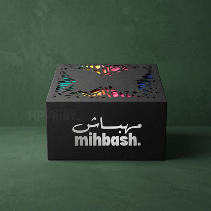 A black die cut product box with laser-cut butterfly wings on top and the brand name 'mihash.' in white on the front, set against a dark green textured background.