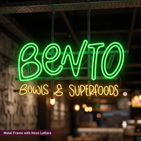 A neon sign reading 'BENTO' in bright green and 'BOWLS & SUPERFOODS' in yellow, mounted on a metal frame in a dimly lit restaurant or bar interior.
