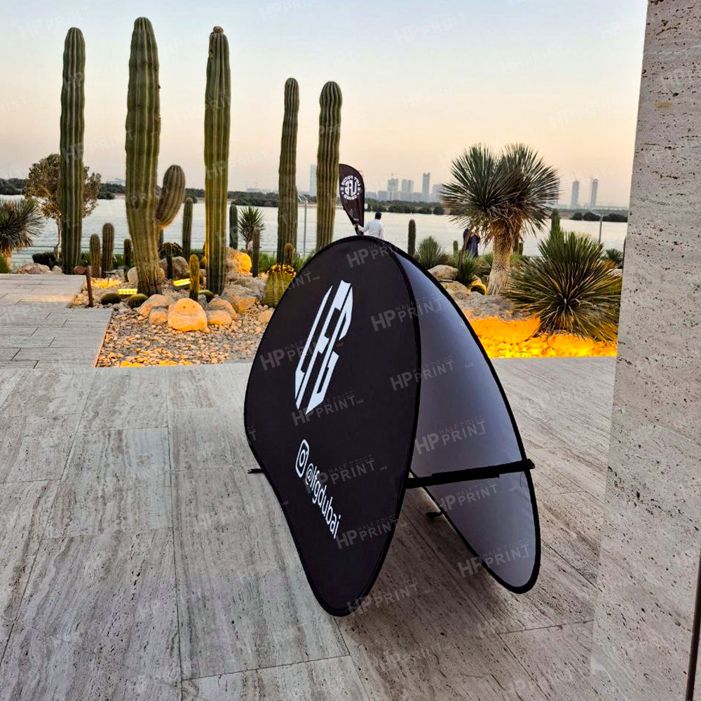 Black and gray pop-up display with HP Print branding in front of a cactus garden.