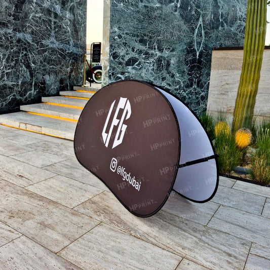 promotional standee with branding on a stone pathway  