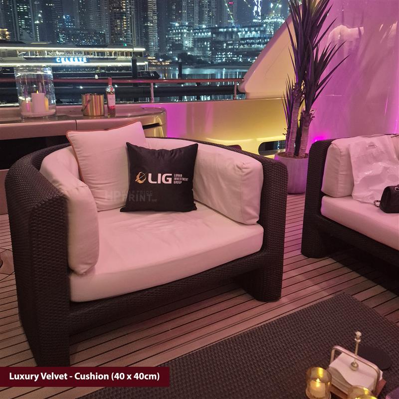 Luxury outdoor seating area with cushions and a cityscape view at night.