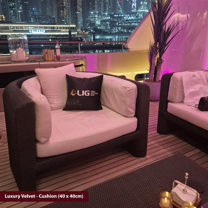 Luxury outdoor seating area with cushions and a cityscape view at night.