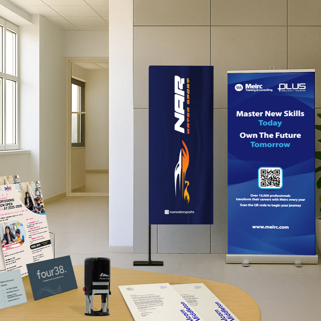 Two promotional banners on a table with brochures in an office setting