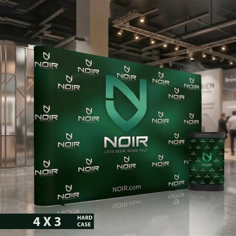 Green NOIR branded pop-up display stand with branding and product packaging in a showroom setting.