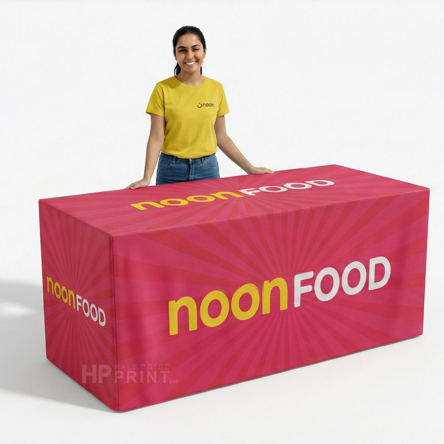 Person standing next to a large pink 'noonFOOD' branded tablecloth on a white background