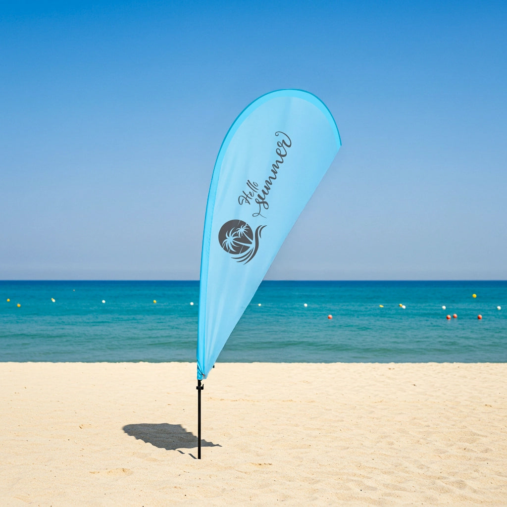Blue beach flag with branding on a sandy beach with ocean and clear sky in the background