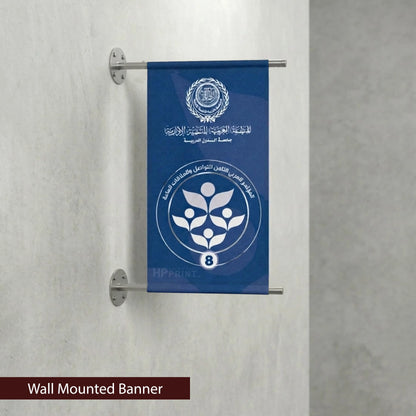 Wall-mounted banner with a blue background and white emblem on a gray wall.