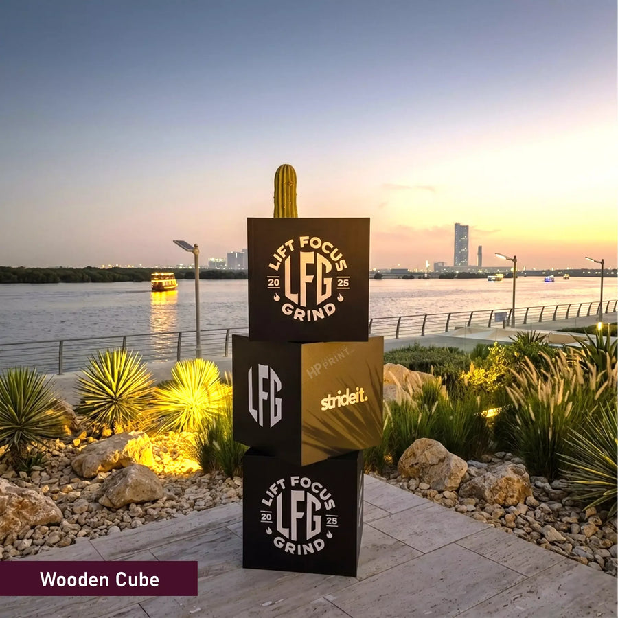 Stack of wooden cubes with branding against a scenic waterfront backdrop