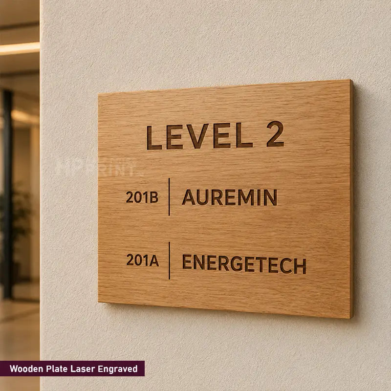 A rectangular wooden plaque engraved with the text 'LEVEL 2', '201B | AUREMIN', and '201A | ENERGETECH', mounted on a textured beige wall. A small label in the bottom-left corner reads 'Wooden Plate Laser Engraved'.